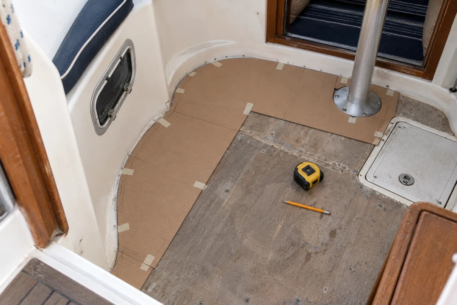 Cardboard templates around an irregular boat floor, a hatch and a pedestal.